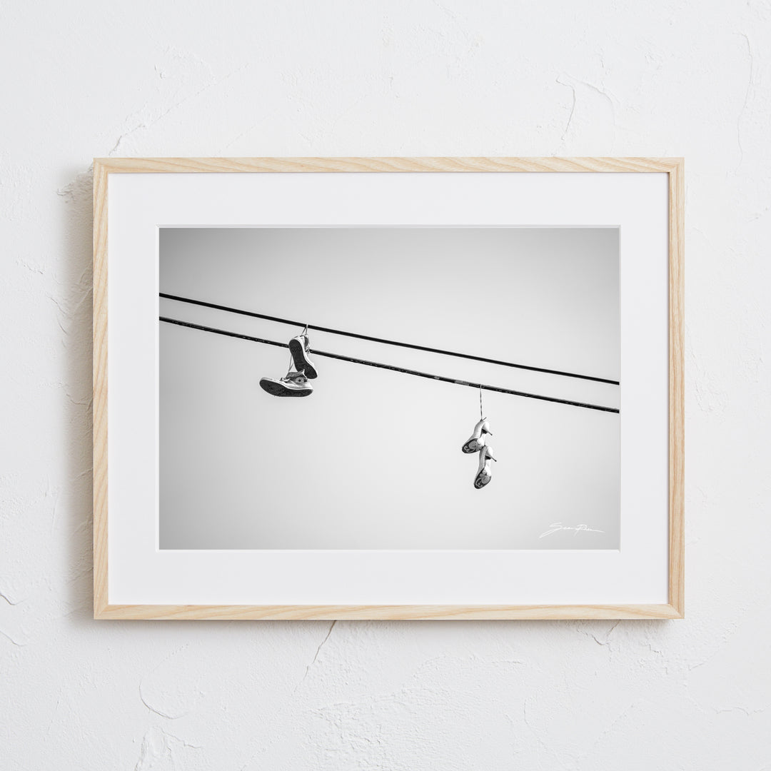 電線に吊るされたスニーカーとヒールのモノクロ写真アートポスター
